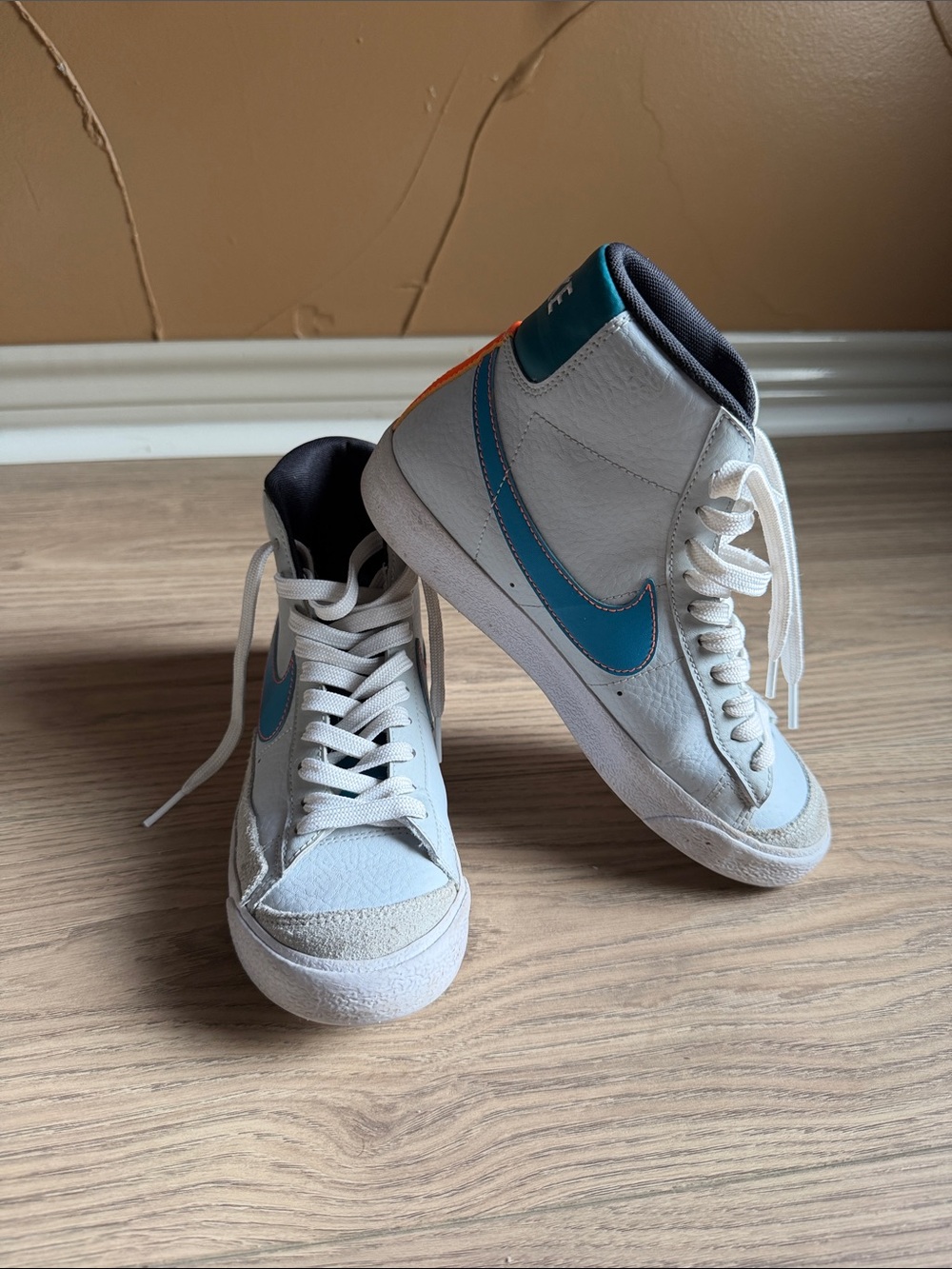 Nike White High-Top Sneakers with Blue Swoosh and Orange Heel Accent